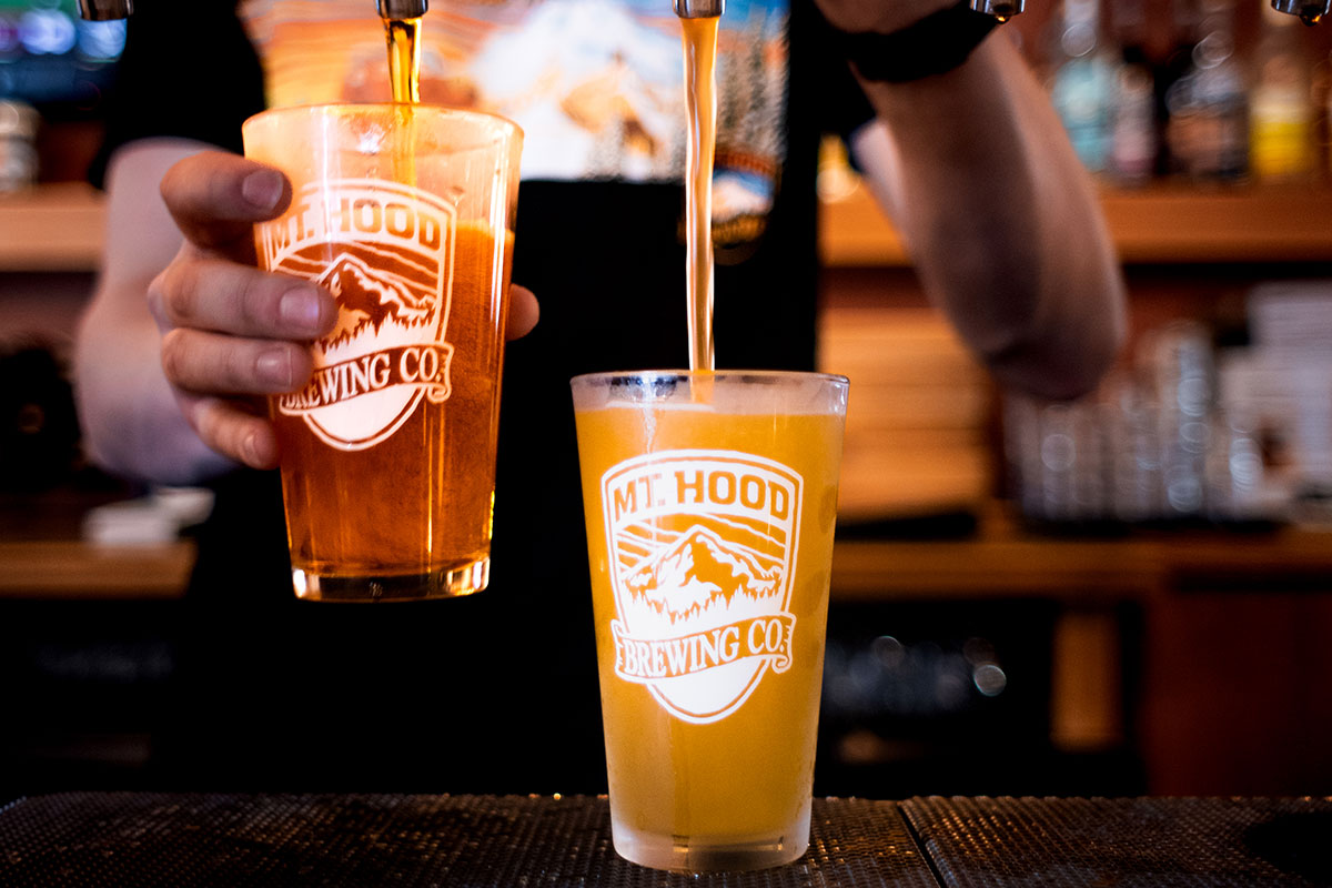 DRAFT BEERS BEING POURED INTO MT. HOOD BREWING CO. PINT GLASSES